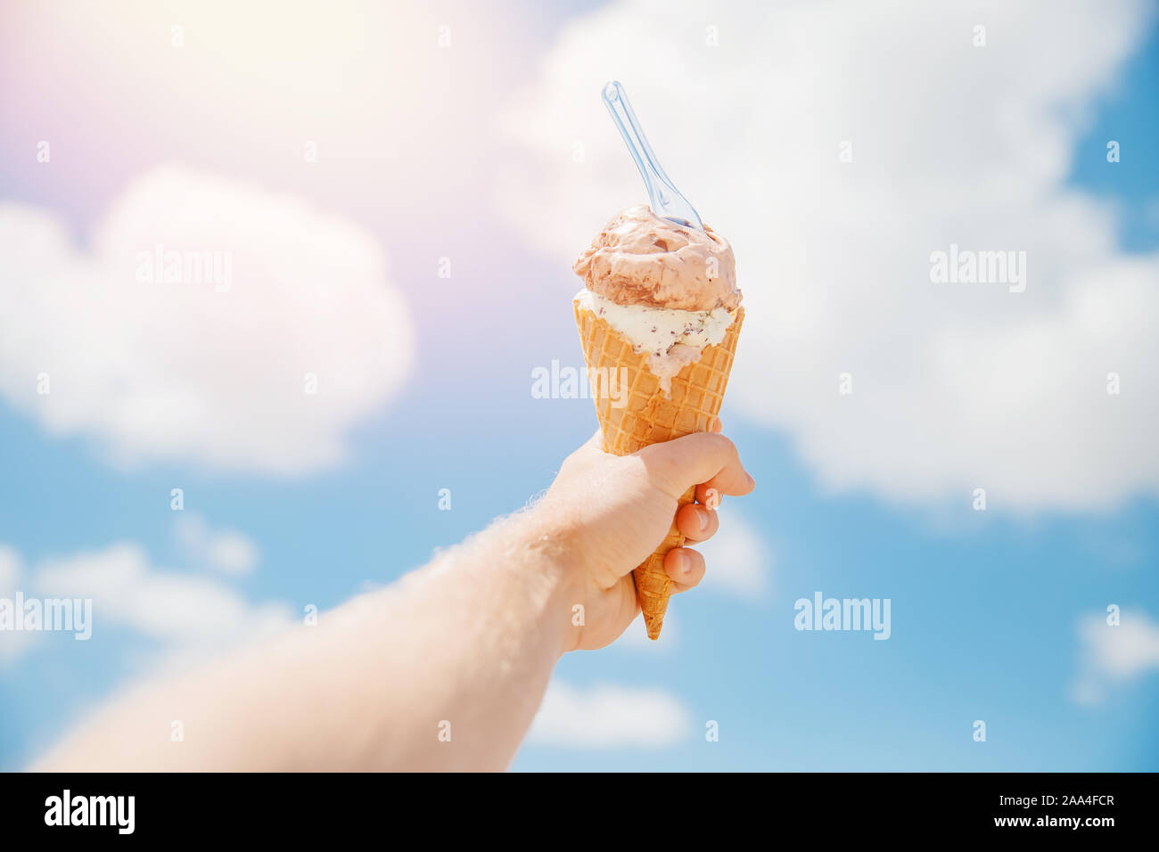 Waffle cone with ice cream on background of blue sky clouds Stock Photo ...