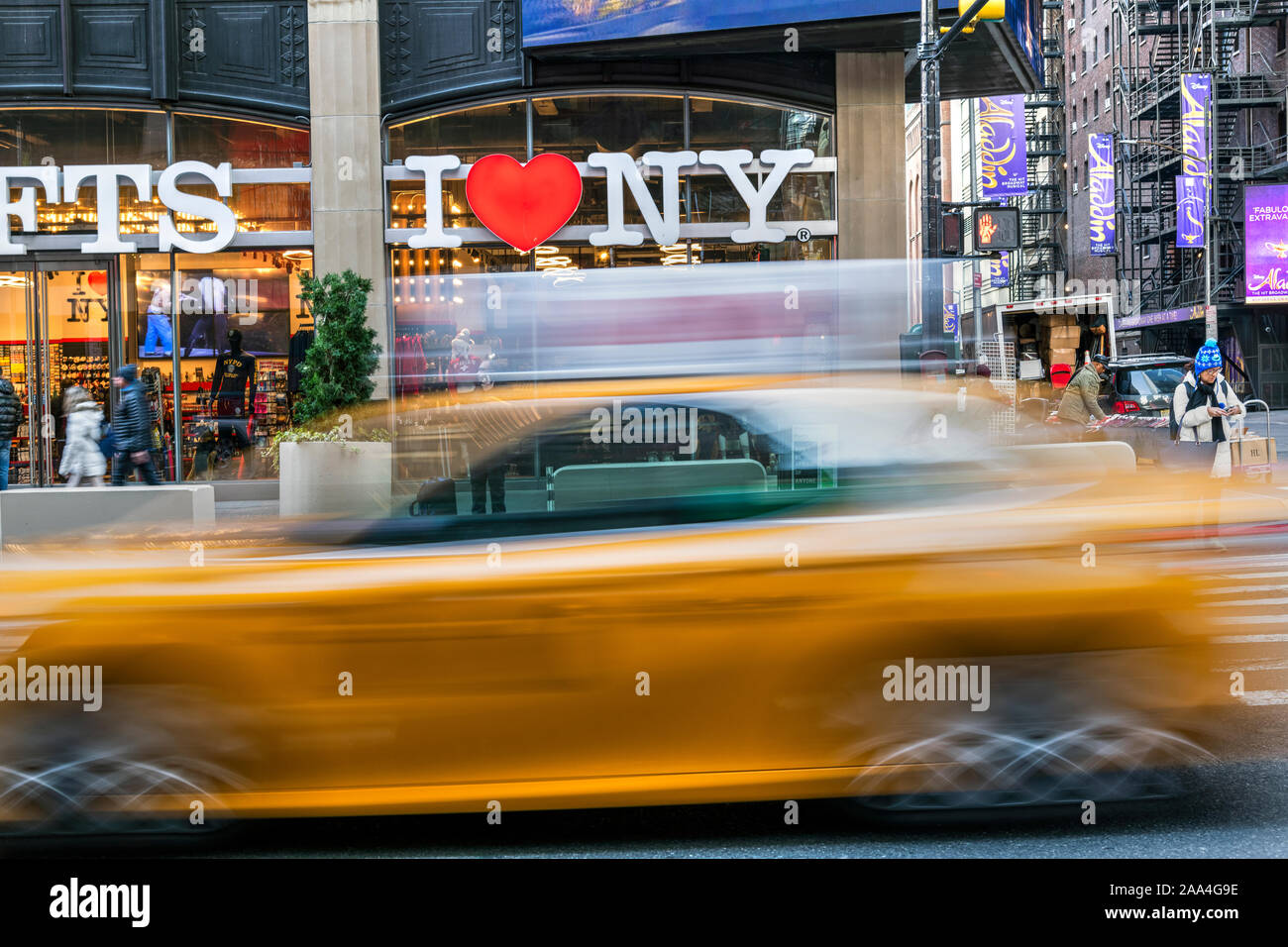 I Love New York gift shop sign and blurred yellow taxi cab passing, Times Square, Manhattan, New York, USA Stock Photo