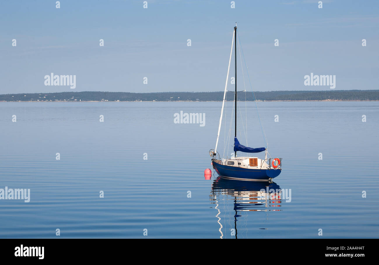 Sailboat at anchor on calm blue water Stock Photo - Alamy