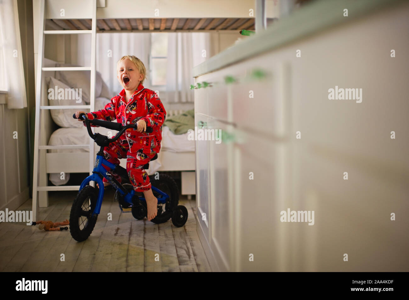 Little boy riding bike with training wheels Stock Photo Alamy