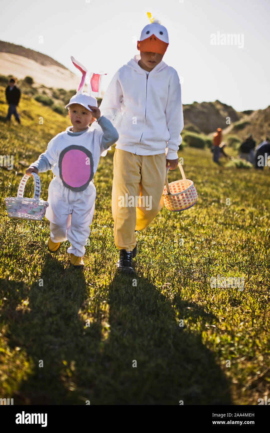 Two brothers in Easter costumes on an Easter egg hunt Stock Photo