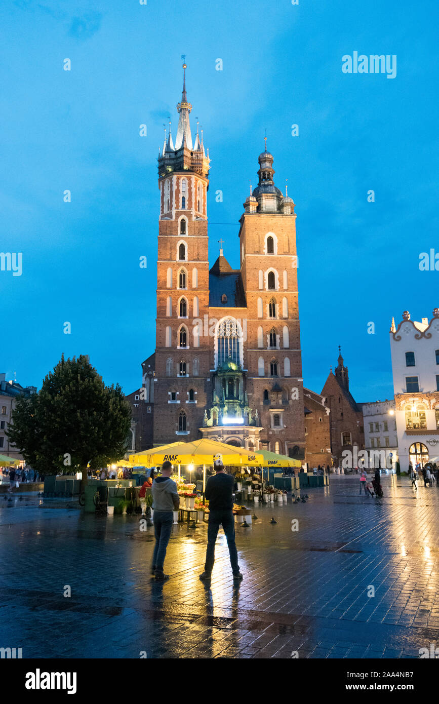St. Mary's Basilica at the Central Market Square (Rynek) of the Old Town of Krakow. It is one of the largest medieval town squares in Europe and it is Stock Photo