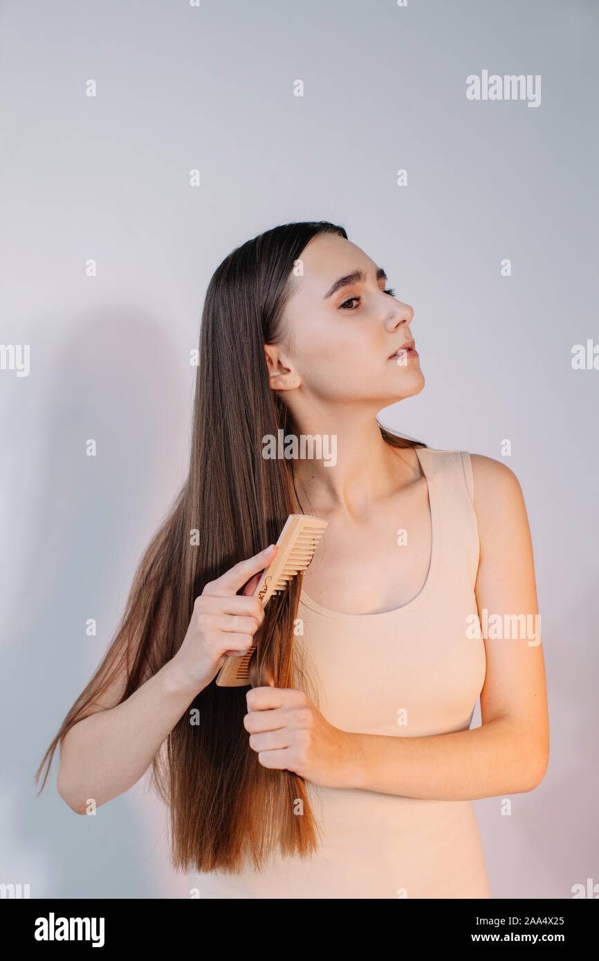 Woman combing her long hair Stock Photo