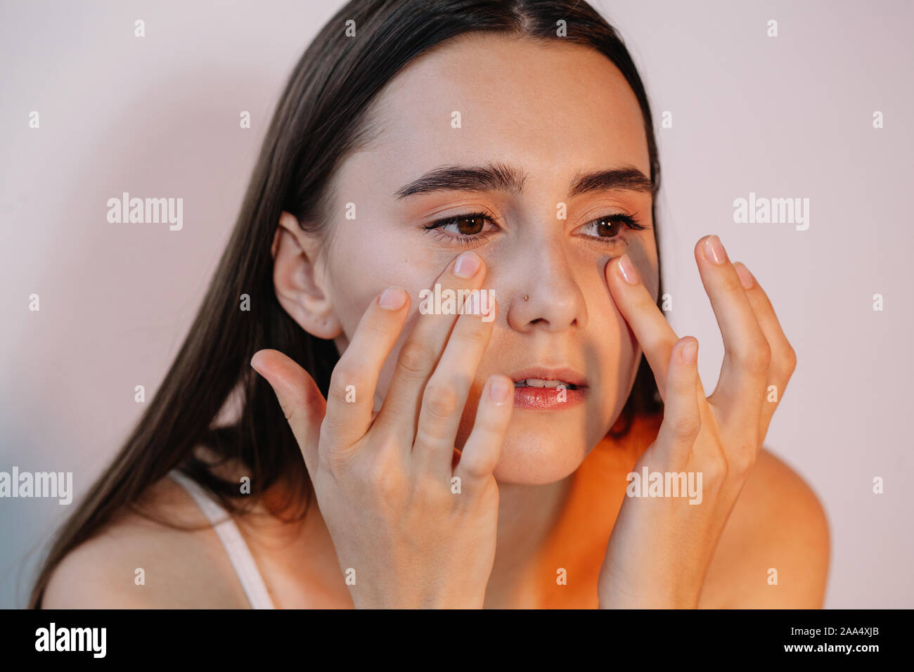 Woman applying eye cream Stock Photo