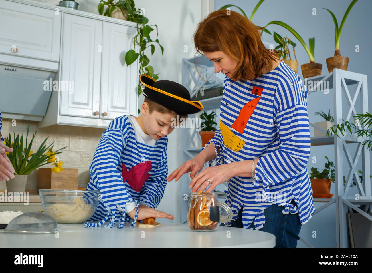 Photo session - friendly family. The family cooks together. Mom and son knead the dough with flour. Prepare the dough in the kitchen. Stock Photo