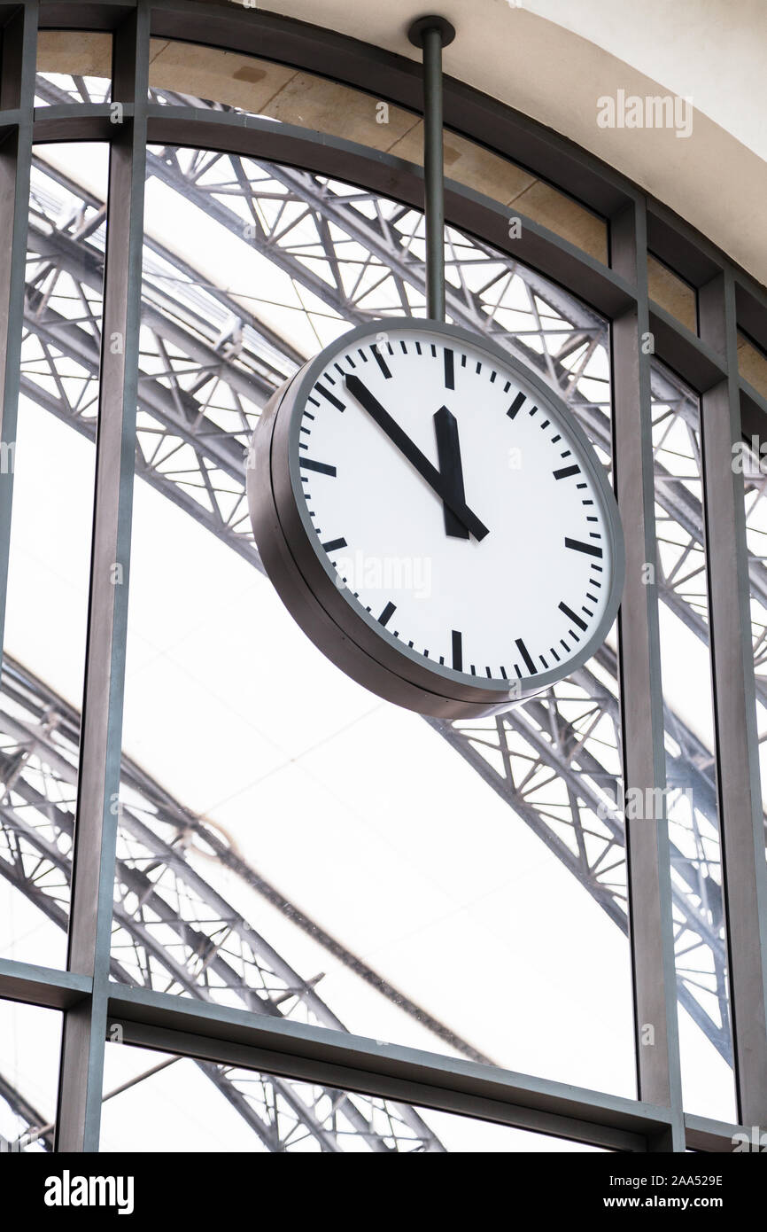 Alone train station's clock hangs on big window Stock Photo