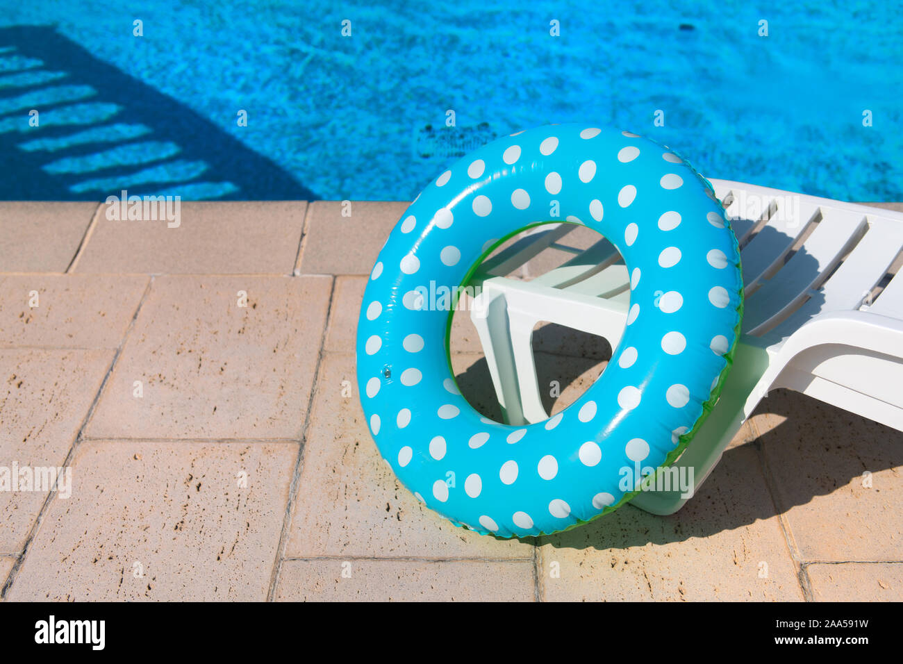 Spotted blue inflatable ring in swimming pool Stock Photo