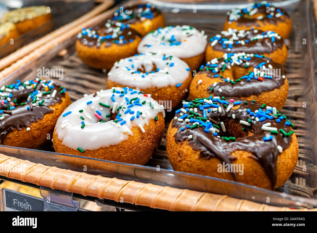 Chocolate and white icing frosting on donuts with blue sprinkles ...