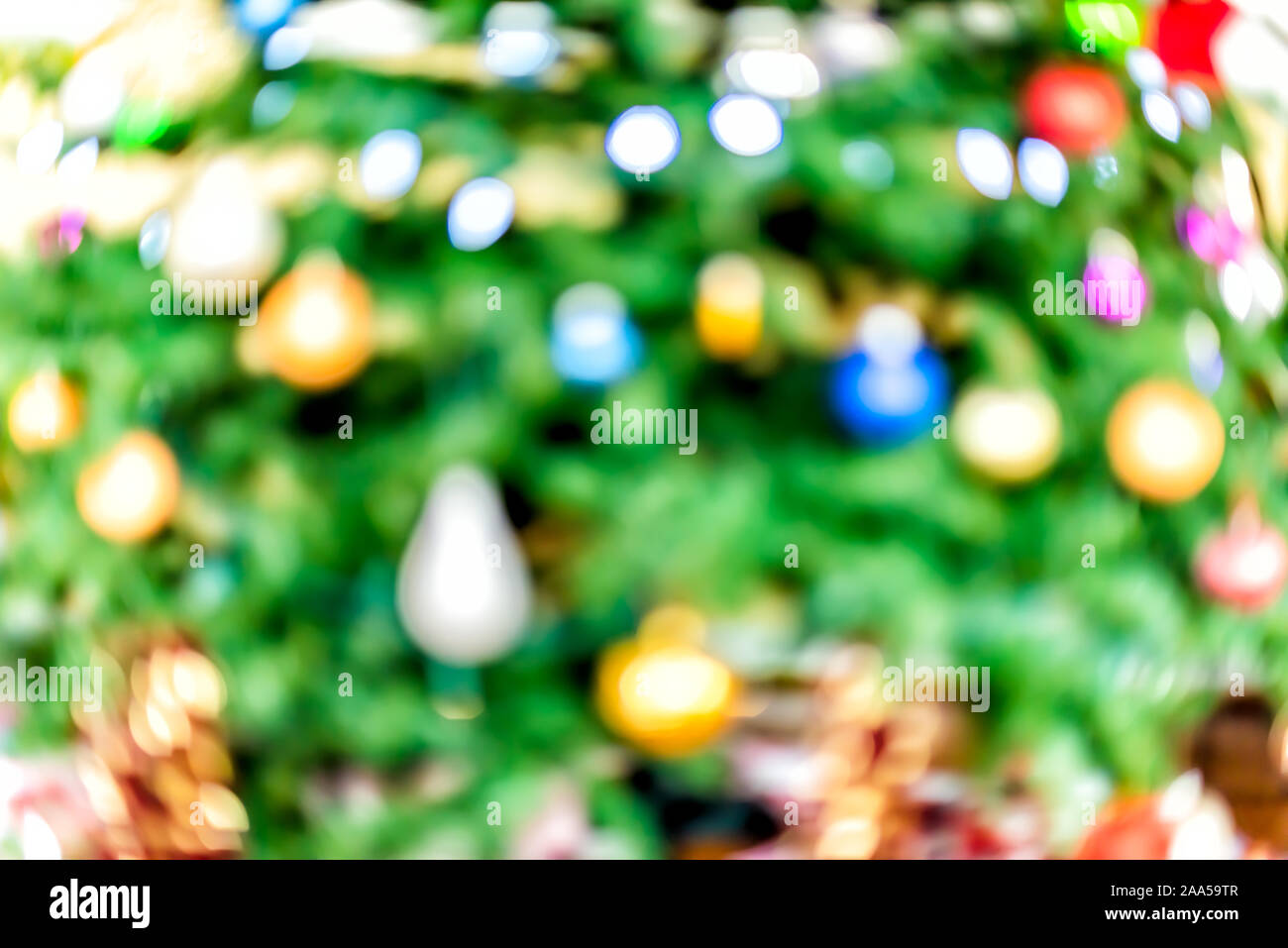 Christmas xmas bokeh abstract background with red, blue and green ornaments decorations on festive tree bright lights Stock Photo
