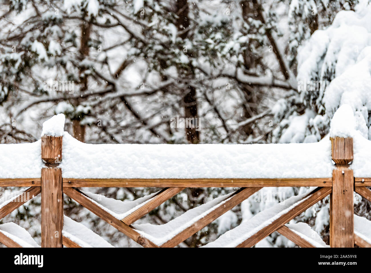 Wooden fence closeup covered in white snow after heavy snowing ...