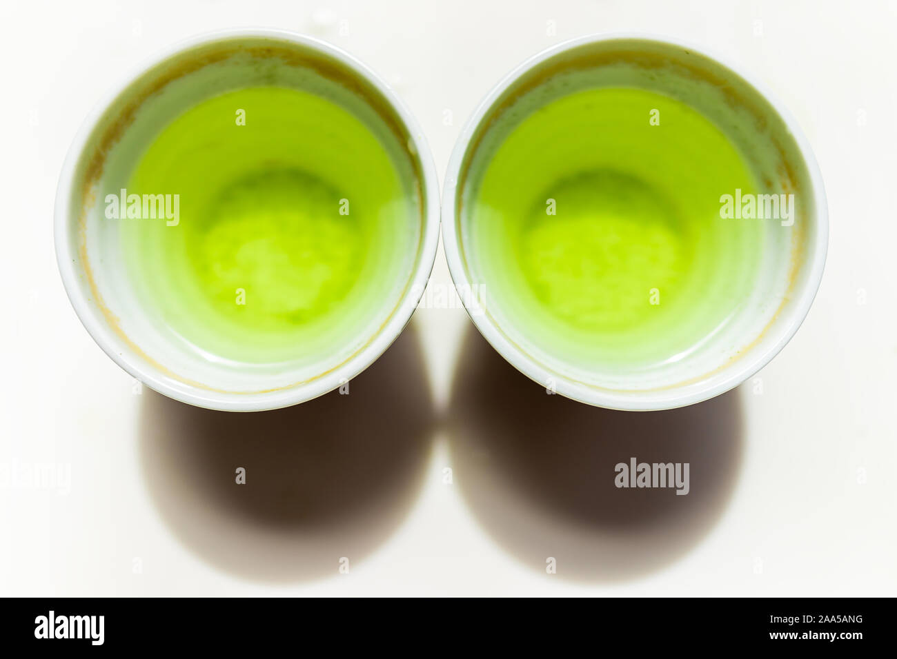 Flat top lay view down of small two cups filled with Japanese vibrant green yellow sencha genmaicha tea color for breakfast or ceremony Stock Photo