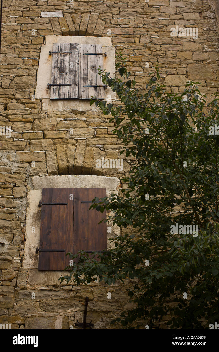 Old windows with closed shutters in stone wall Stock Photo - Alamy