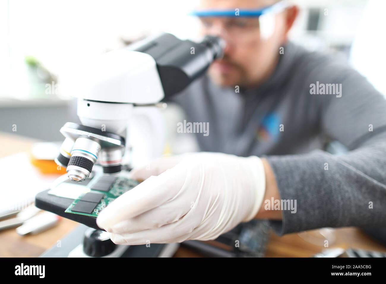 Man soldering using microscope Stock Photo Alamy