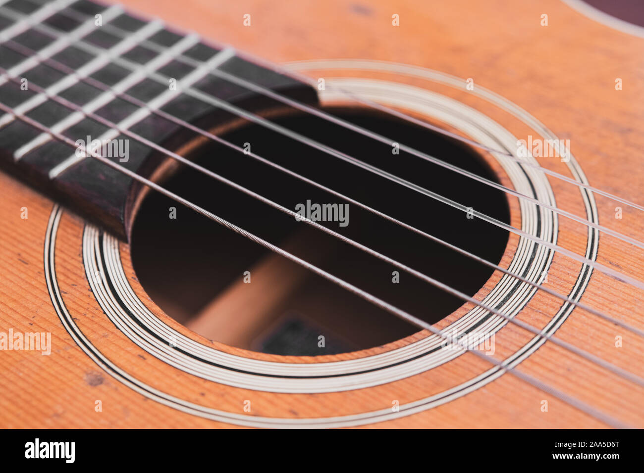 Macro detail music concept acoustic guitar chords body and hole wooden vintage scratched soundboard Stock Photo