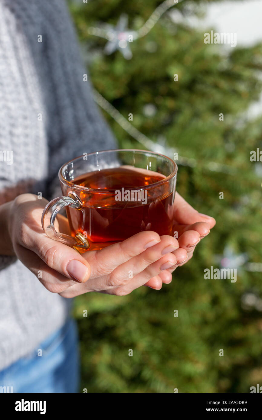 Tea cup in girl's hands, close up picture of tasty beverage at holiday background, macro concept of cozy lifestyle Stock Photo