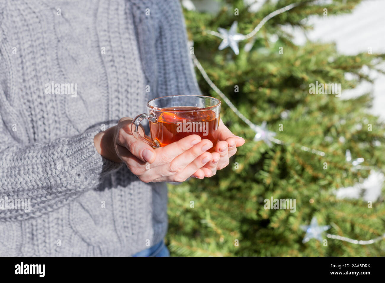 Close up hands with hot drink. Concept of warm cozy lifestyle at sunny day Stock Photo