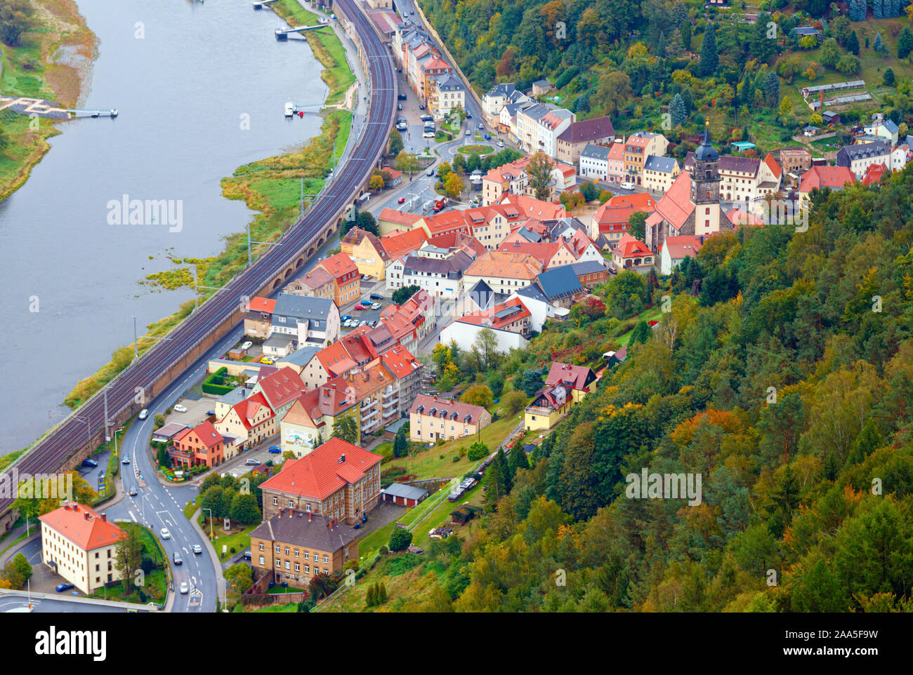 Aerial view of the river Elbe and Konigstein town centre, surrounded by forests in autumn colours. Konigstein is a small town in Saxony, Sachsische Sc Stock Photo