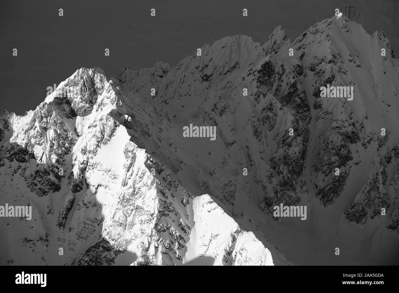 Black and white aerial photo of a peak in the Tordrillo Mountains of Alaska, shot in wintertime. Stock Photo