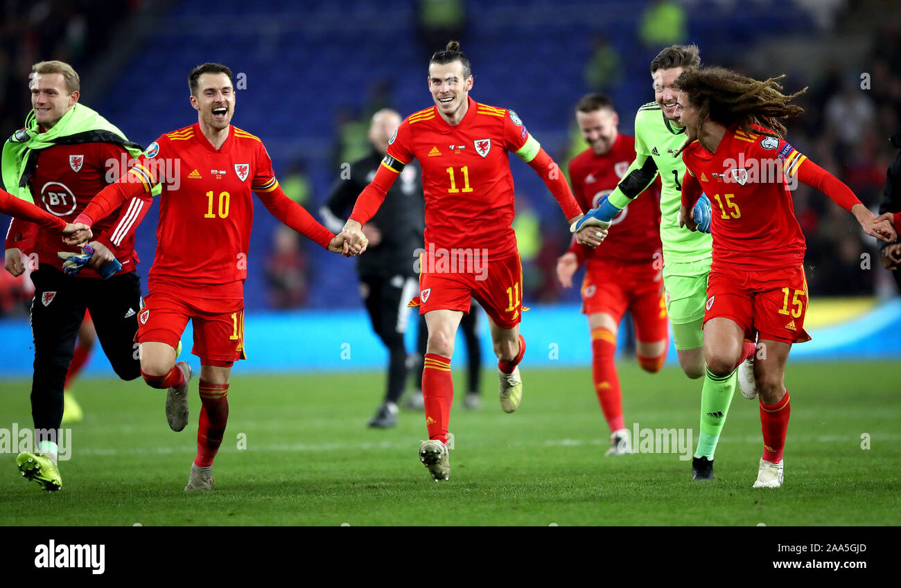 Wales' Aaron Ramsey (left to right) Gareth Bale, Wayne Hennessey and Ethan Ampadu (right) celebrate victory and qualification after the final whistle during the UEFA Euro 2020 Qualifying match at the Cardiff City Stadium. Stock Photo