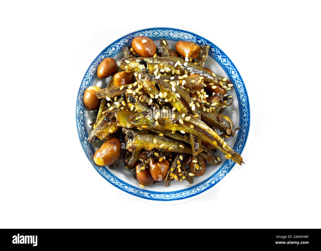 Tazukuri, candied sardines in a dish. Dried sardines lightly coated with honey, roasted sesame and peanuts. Stock Photo