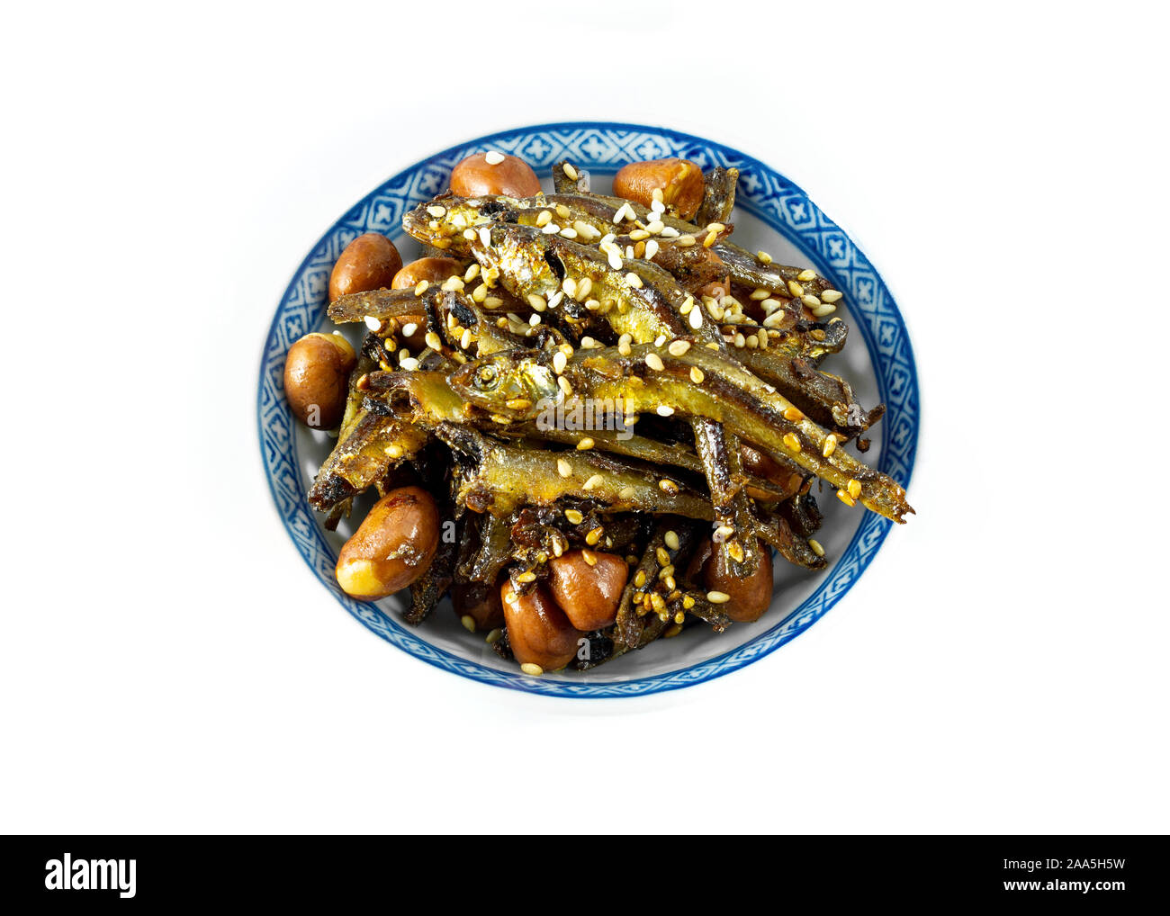 Tazukuri, candied sardines in a dish. Dried sardines lightly coated with honey, roasted sesame and peanuts. Stock Photo