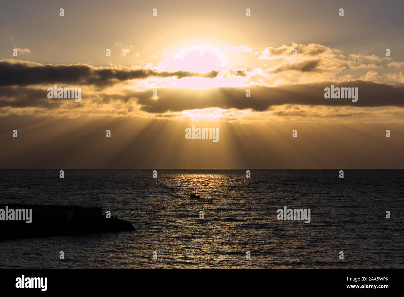 Game of light and shadow generated by the sunrise and clouds covering the  sky over the sea Stock Photo - Alamy