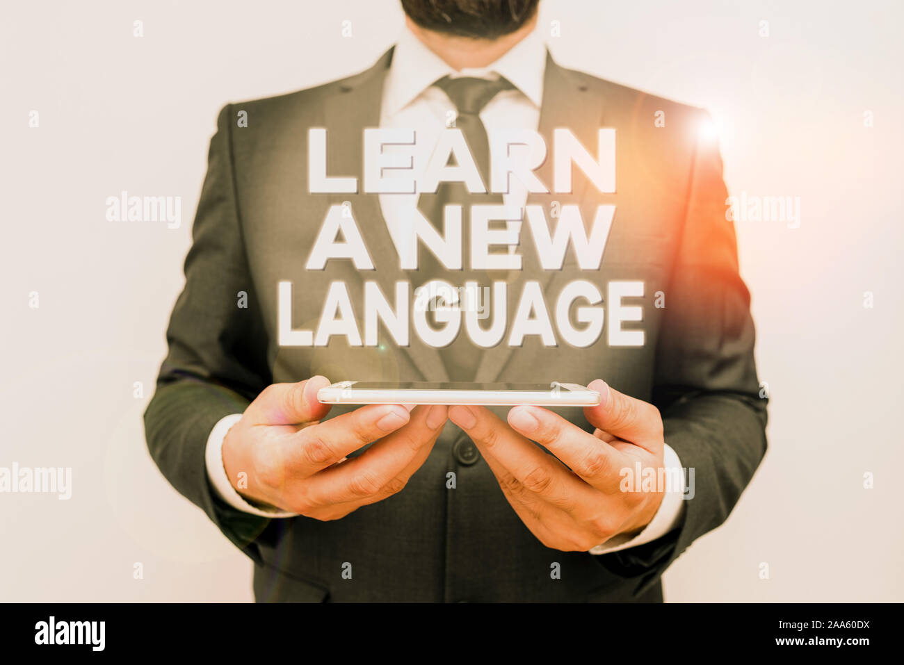 Text sign showing Learn A New Language. Business photo text Study Words other than the Native Mother Tongue Male human wear formal work suit hold smar Stock Photo
