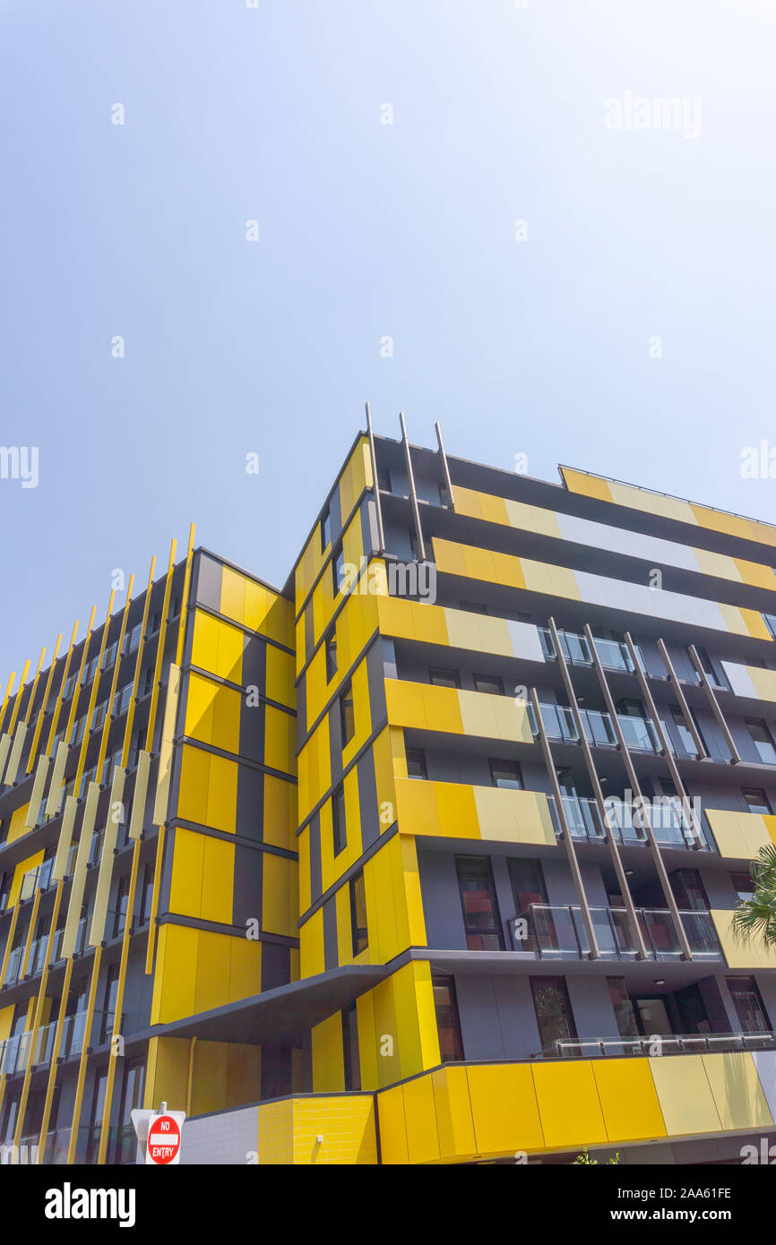 Medium-rise apartment building painted in yellow .from street below Stock Photo