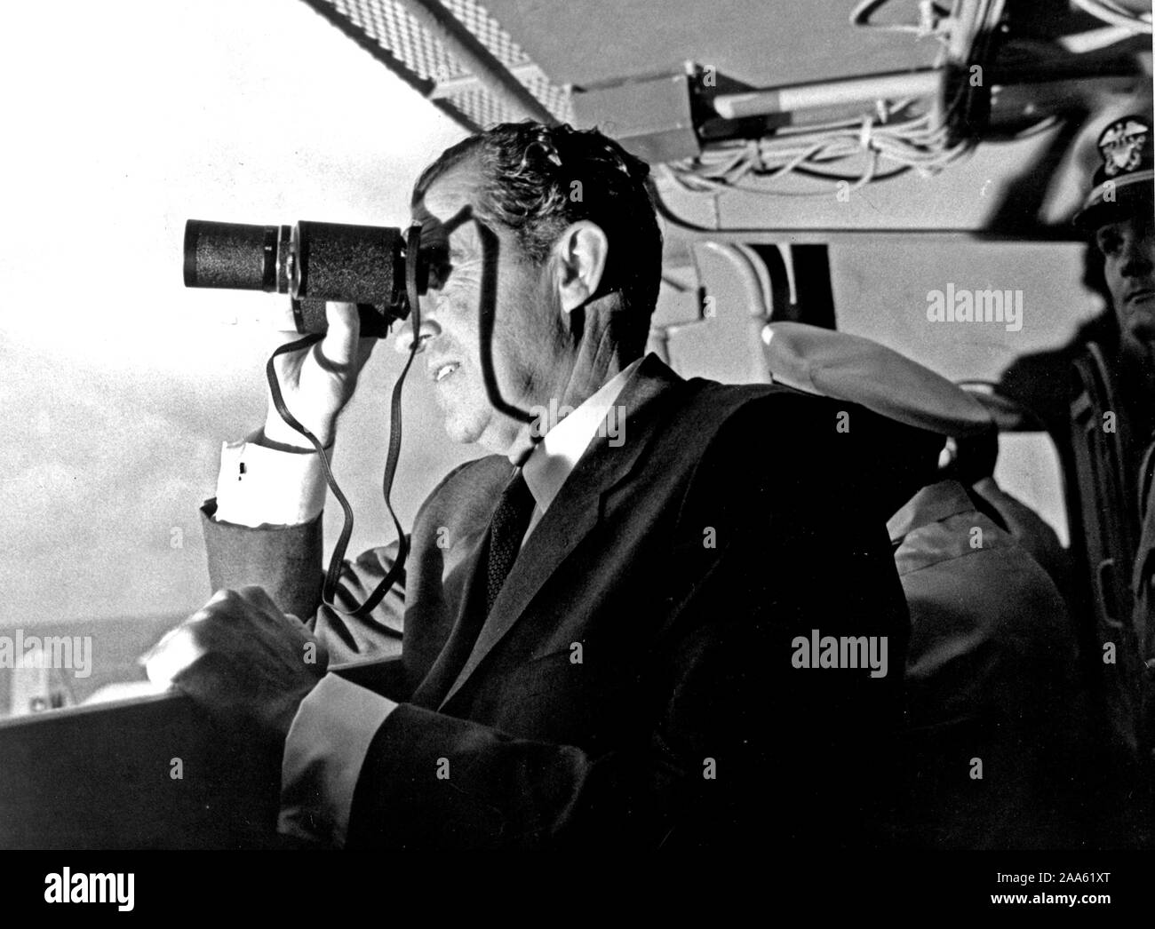 U.S. President Richard Milhous Nixon, aboard the U.S.S. Hornet aircraft carrier, used binoculars to watch the Apollo 11 Lunar Mission recovery. Stock Photo