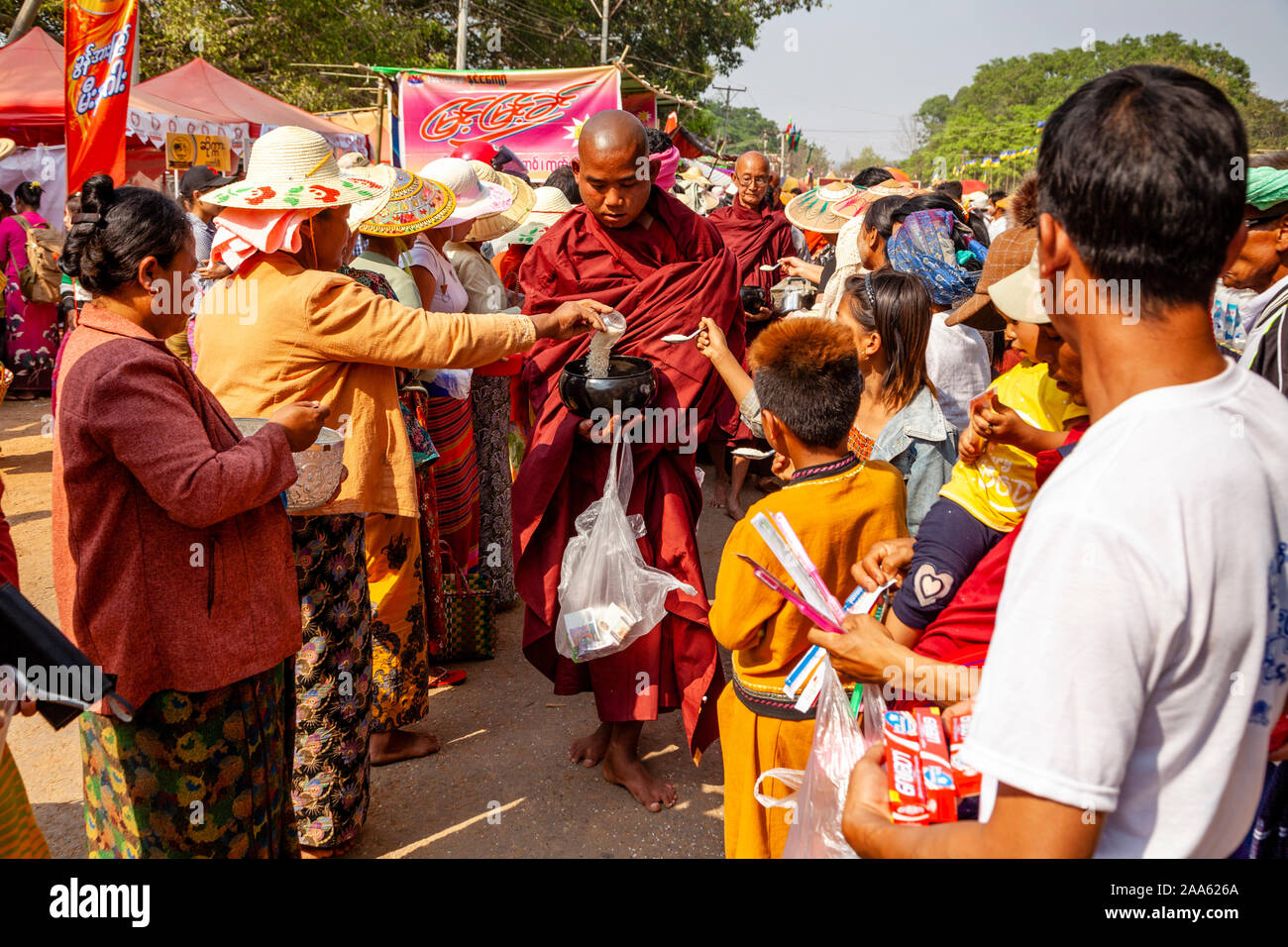Monks Walk Down The Main Street In Pindaya Seeking Alms During The Pindaya Cave Festival, Pindaya, Shan State, Myanmar. Stock Photo