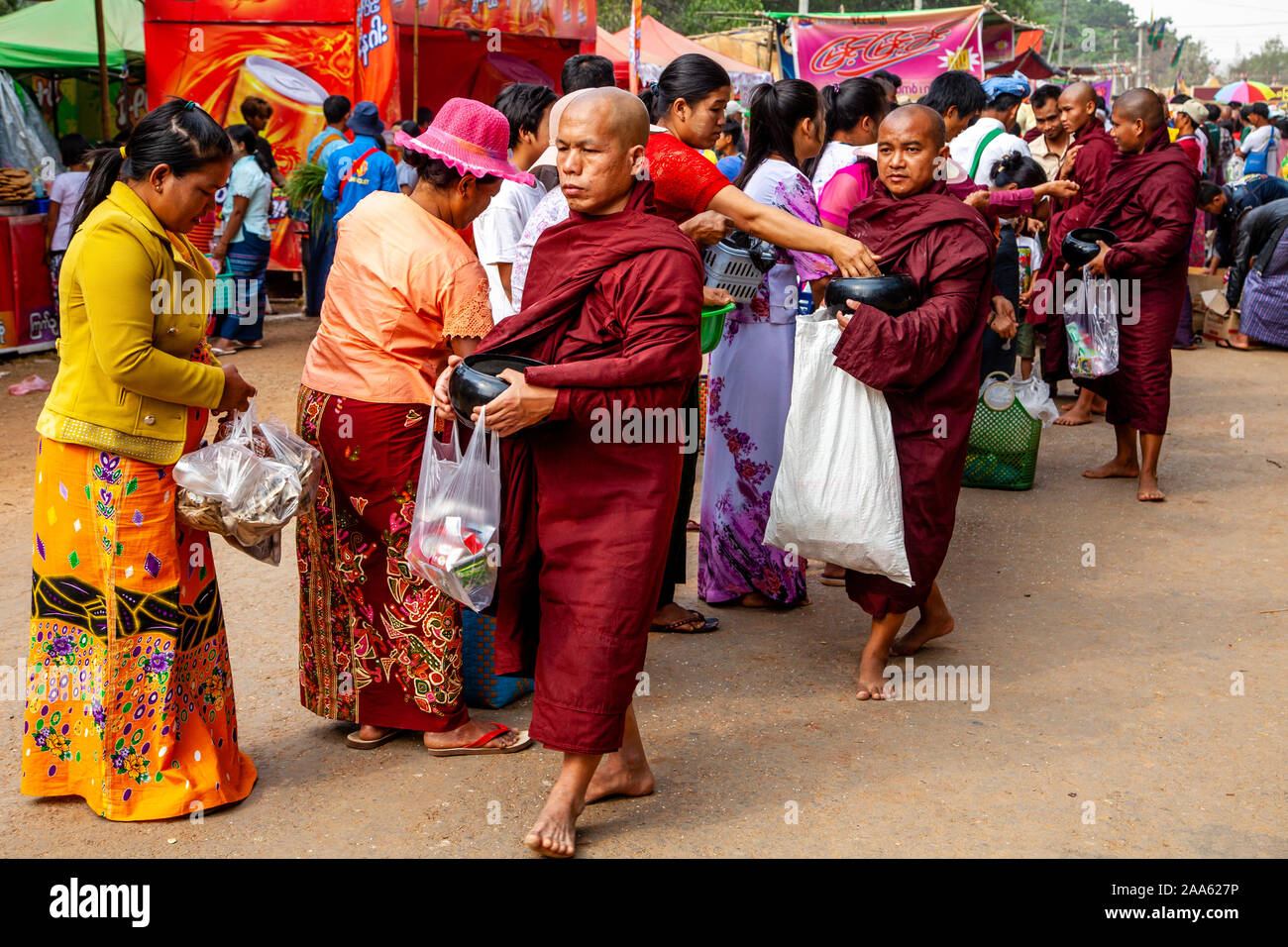Monks Walk Down The Main Street In Pindaya Seeking Alms During The Pindaya Cave Festival, Pindaya, Shan State, Myanmar. Stock Photo