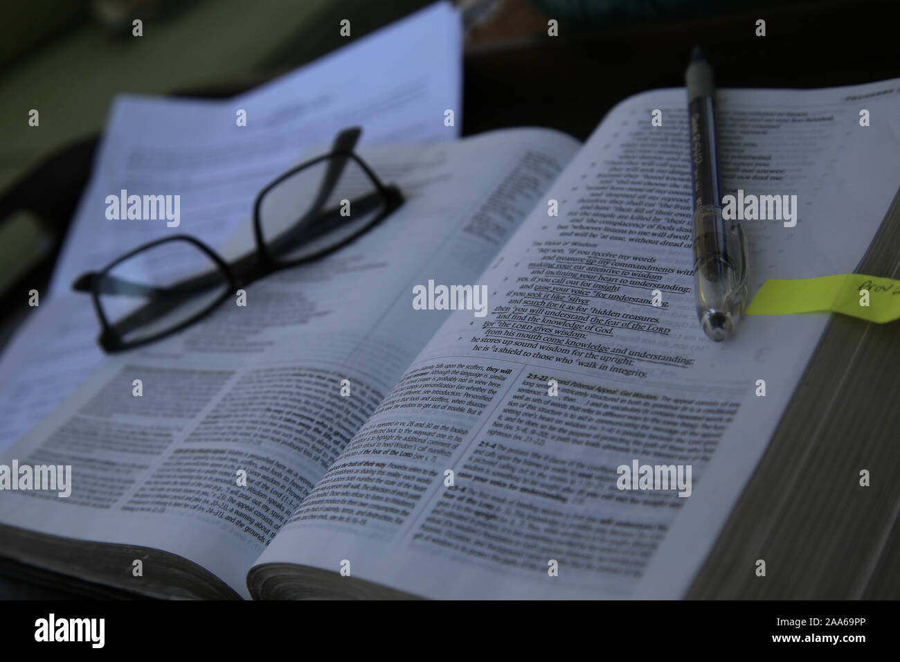 Bible opened to a verse during a bible study with reading glasses and a pen. Stock Photo