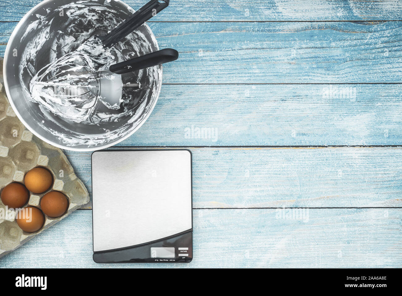 Baking utensils in mixer bowl after cake frosting, weighing scale and