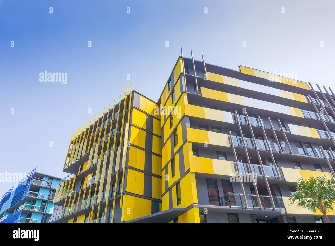 Gold Coast Australia - November 19 2019; Exterior of striking yellow and blue  apartment blocks and commercial building shot from street below looking Stock Photo