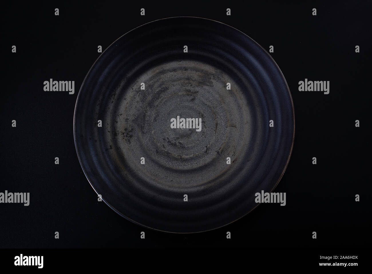 a dark grey ceramic plate with a water ripple Stock Photo