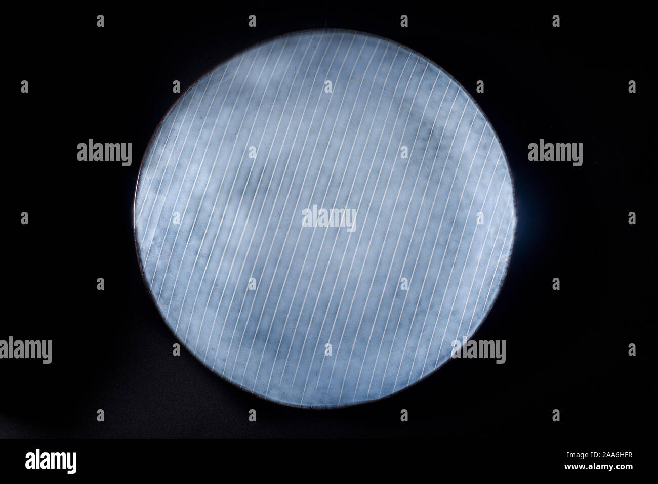 a dark blue ceramic plate with parallel stripes Stock Photo