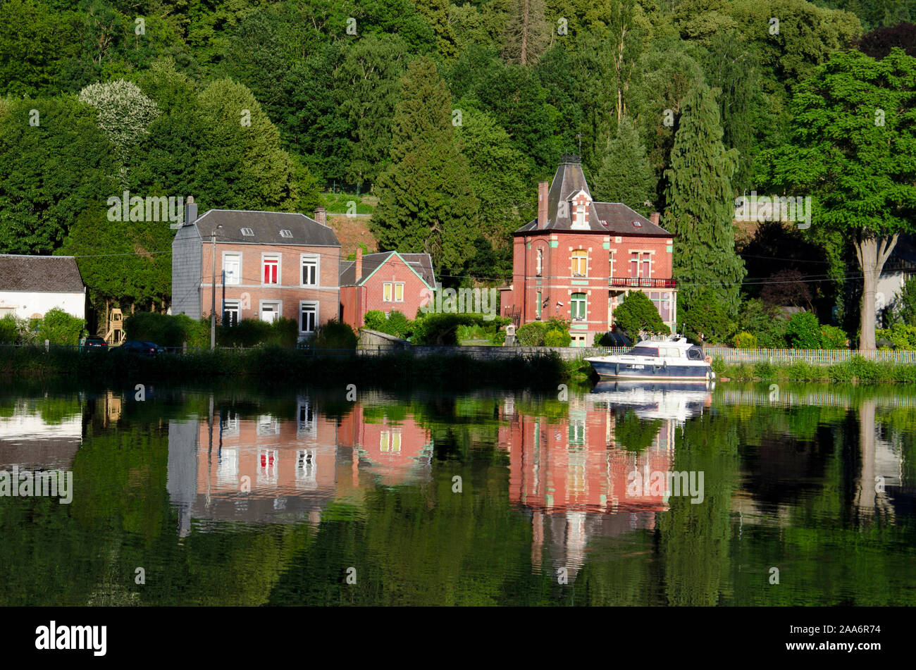 Colourful houses and tourist boats cruising along the River Meuse, Dinant, Namur, Belgium, Europe Stock Photo