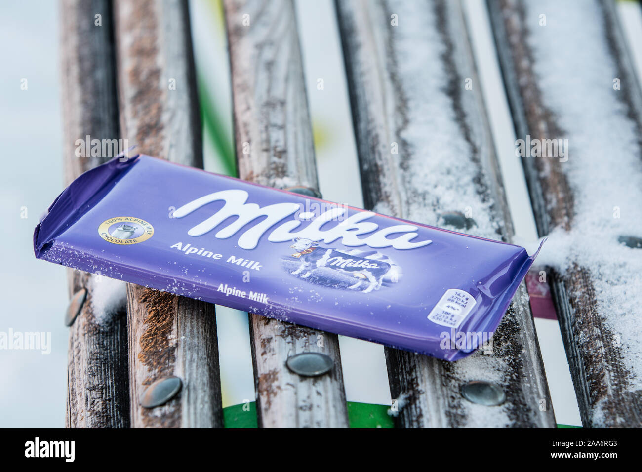 A bar of Milka Mondelez Alpenmilch milk chocolate with the purple cow, winter, snow Stock Photo