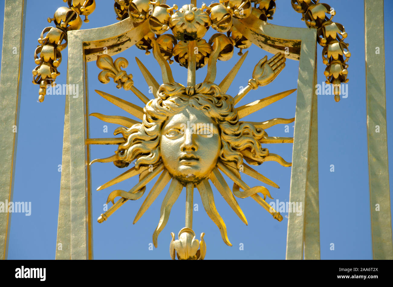 Details of the sun symbol in golden exterior fence at the facade of the palace, Versailles, France, Europe Stock Photo