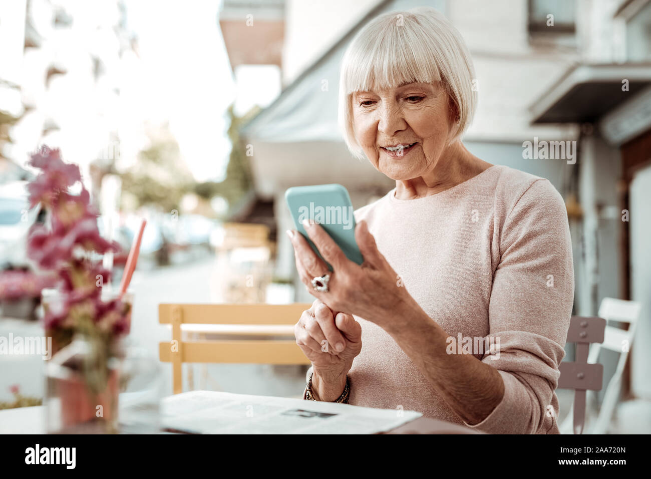 Nice elderly woman looking at her smartphone screen Stock Photo