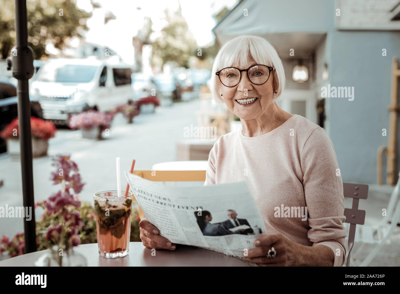 Joyful happy woman reading a morning newspaper Stock Photo