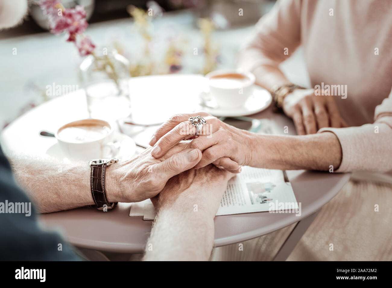 Nice aged woman touching her husbands hands Stock Photo