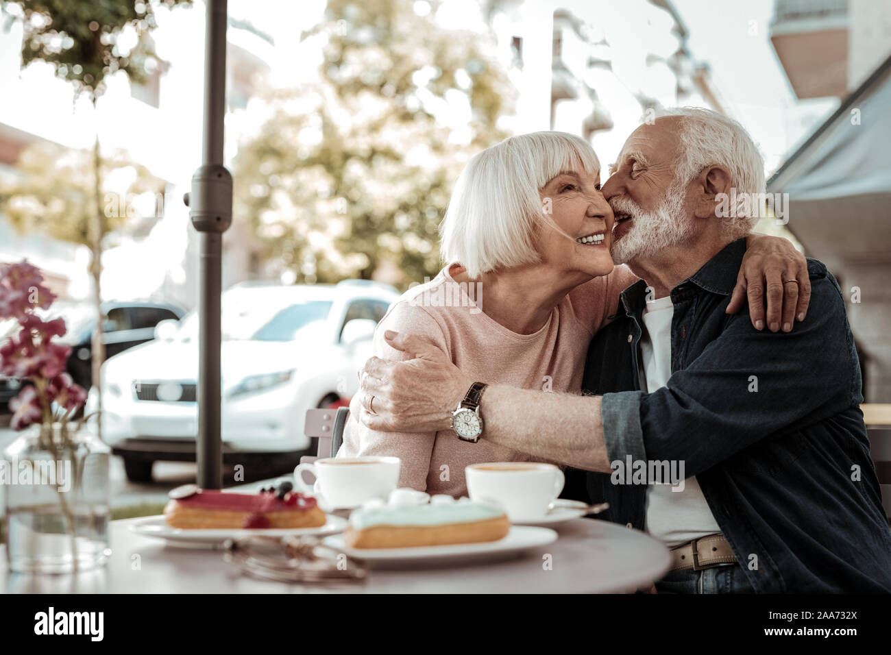 Joyful senior man wanting to kiss his wife Stock Photo