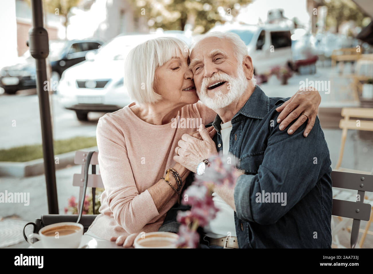 Positive grey haired woman hugging her husband Stock Photo