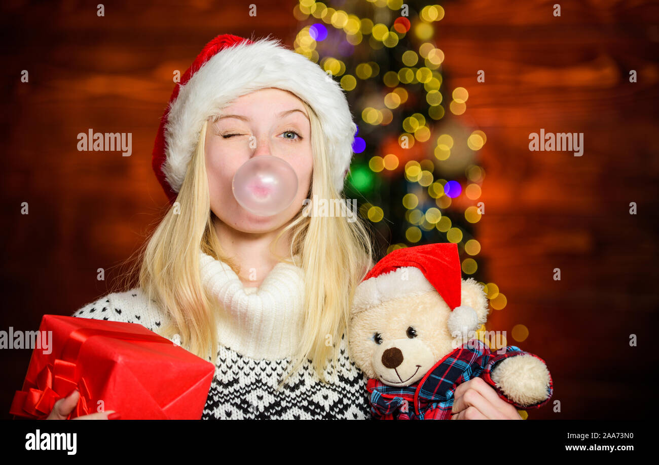 Blow Bubbles with Gum. Only fun on my mind. Girl Santa claus making big bubble with gum. Funny face close up. Adorable woman blowing bubble. Christmas girl made bubble bubblegum. Breathe gently. Stock Photo