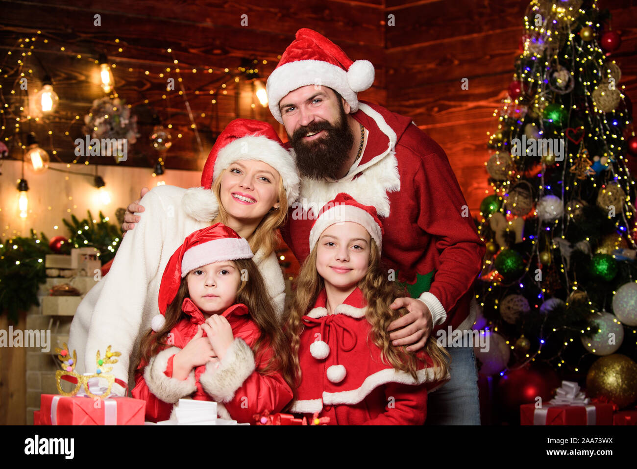 Capturing a happy moment. Happy family celebrate new year. Portrait loving  family. lot of xmas present boxes. merry christmas. Father and mother love  kids. small children and parents in santa hat Stock