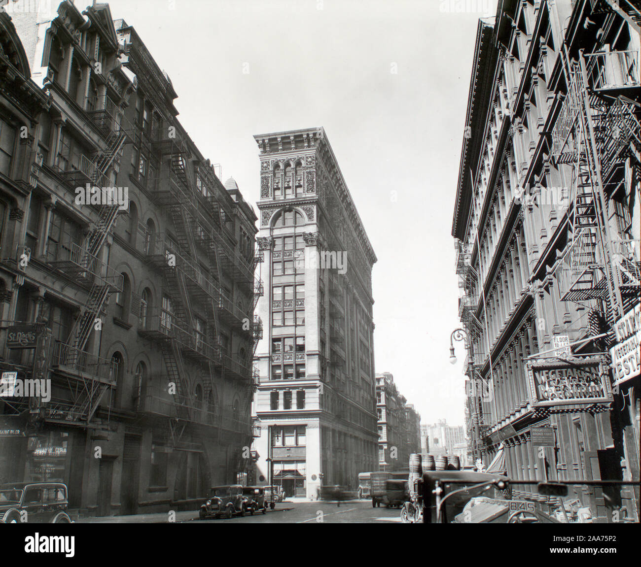 Code: I.A.2. Citation/Reference: CNY# 4 Looking down Broadway, ornate Bank of Sicily Trust near center of image, sign for vegetarian restaurant, right, cars and trucks.; Broadway near Broome Street, Manhattan. Stock Photo