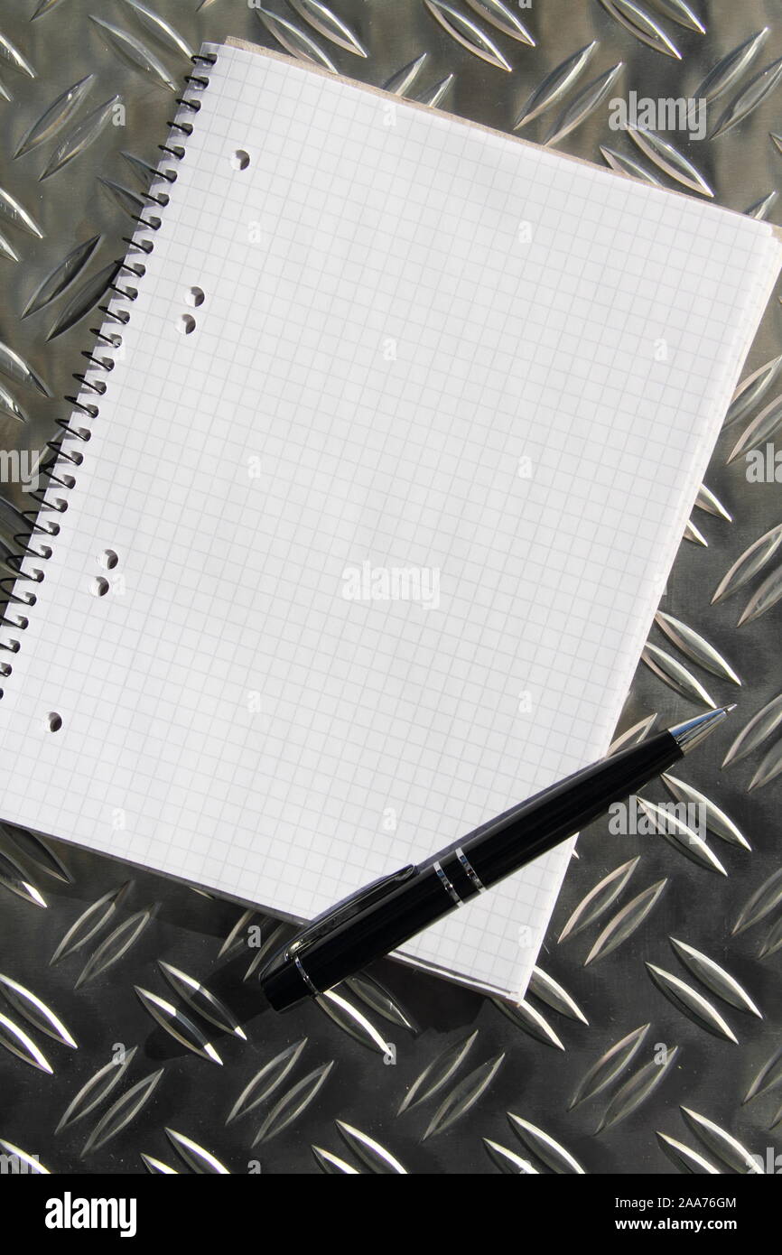 empty writing pad with pen on a table Stock Photo