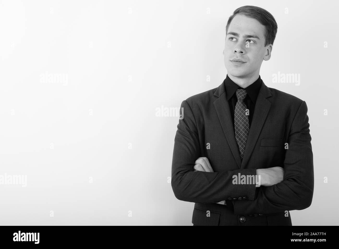 Portrait of young handsome businessman wearing suit in black and white ...