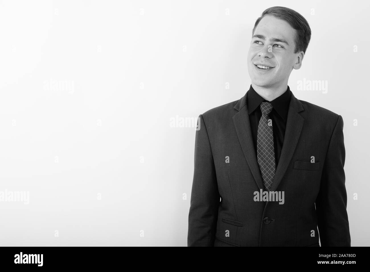 Portrait of young handsome businessman wearing suit in black and white ...
